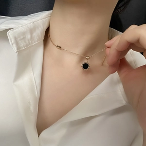 Collier en or rose avec pendentif à chiffres romains noirs porté par un modèle