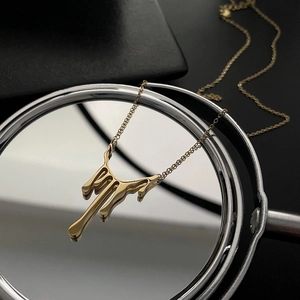 Collier avec pendentif goutte de lave dorée polie sur base miroir réfléchissante
