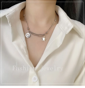 Close-up of double-layered silver smiley face necklace with star pendant for women