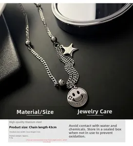 Macro detail of silver titanium steel layered necklace with smile and star pendants