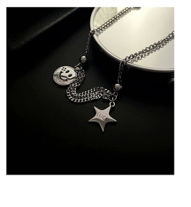 Close-up of titanium steel necklace with silver smile face and star pendants