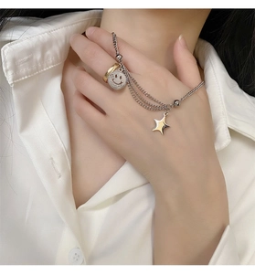 Close-up of double-layer titanium necklace with smiling face, ring and star charms