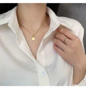 Dettaglio della collana dorata con ciondolo Good Luck e set di anelli coordinato