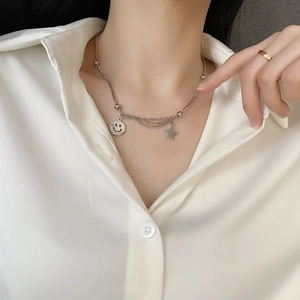 Silver layered titanium steel necklace with smile pendant and star on a model