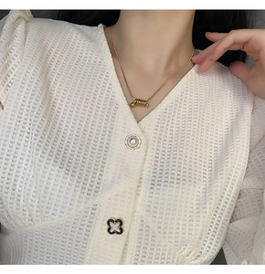Détail du collier chaîne serpent dorée avec pendentif à ressort sur haut en dentelle