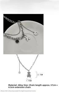 Detail of silver double-layered teddy bear necklace with black disc and smiley face pendant