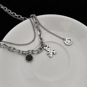 Macro shot of double-layered bear necklace featuring black panda pendant and silver charms