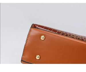 Vue détaillée du fond du sac en cuir croco marron avec pieds de protection dorés