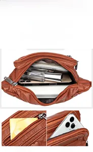 Detail view of large capacity brown leather waist bag with multiple zipper compartments