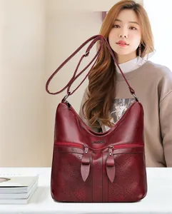 Détail du sac hobo vintage bordeaux en similicuir avec poches zippées et texture grainée