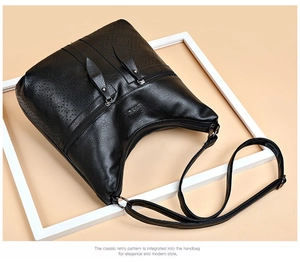 Détail du sac bandoulière vintage en cuir PU noir avec motif texturé perforé décoratif