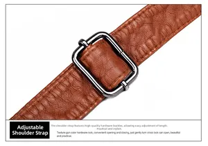 Macro shot of brown pebble grain leather strap with adjustable gunmetal buckle detail