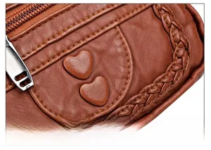 Detail of brown litchi leather waist bag featuring woven edges and heart charms