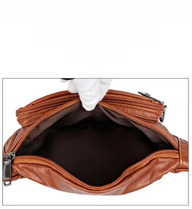 Interior view of brown faux leather waist bag showing fabric lining and metal zipper