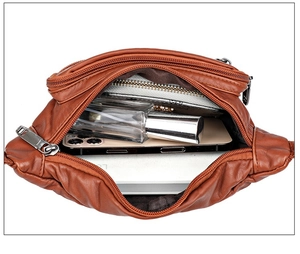 Brown soft leather fanny pack showing spacious main compartment with zipper pockets