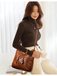 Détail du sac bandoulière vintage en cuir PU marron avec motifs ajourés et logo métal