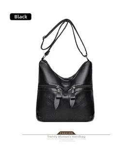 Détail du sac à bandoulière en similicuir noir avec poches zippées et tirettes en forme de feuille