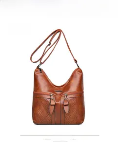 Détail du sac hobo en similicuir marron vintage avec perforations laser et double zips