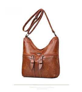 Détail du sac en cuir PU marron vintage avec poches zippées et motifs découpés laser