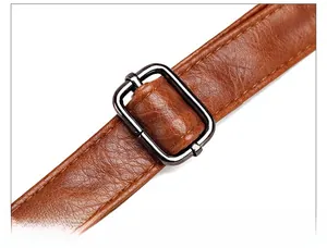 Détail de la bandoulière en cuir PU marron avec boucle de réglage en métal gris foncé robuste