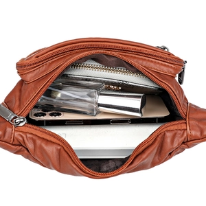 Brown soft leather waist bag showing internal capacity with phone and accessories