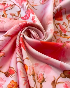 Macro view of pink floral rose print on silky satin fabric with elegant drapery