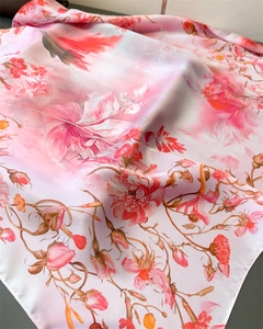 Detailed close-up of floral print silk scarf featuring pink peonies and soft draping texture