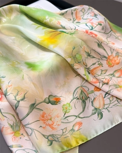 Close-up of silky floral scarf showing elegant rose prints and glossy fabric texture