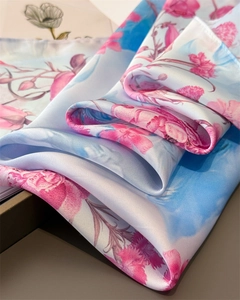 Detailed close-up of pink floral and blue gradient silk-like fabric with satin luster