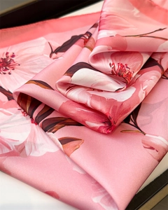 Vue détaillée d'un foulard en soie rose avec d'élégants motifs de fleurs de cerisier