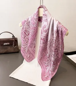 Detail of floral printed silk scarf showing light pink gradient and scroll patterns