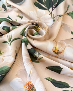 Gros plan du tissu de foulard en soie avec imprimé floral champagne et texture satin
