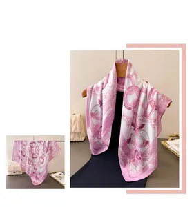 Macro detail of high-quality pink silk scarf featuring elegant chain and floral prints
