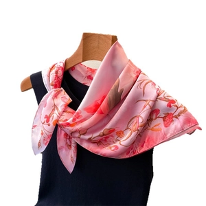 Elegant floral pink silk scarf tied on a black top showcased on a wooden hanger