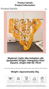 Detail view of orange silk satin scarf featuring luxury gold chain and heart print patterns