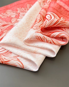Close-up of silk-like satin fabric showing luxury floral print and smooth texture