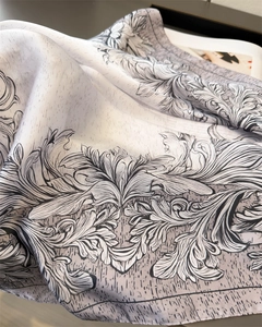 Detail of grey baroque leaf print silk scarf with smooth draped texture and fine edges
