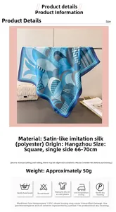 Detail of blue geometric silk-feel scarf next to a white handbag and a magazine