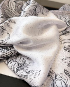 Detail of silk scarf showing vintage floral print and smooth satin texture in black and white