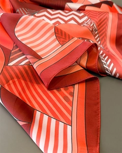 Close-up of geometric print silk scarf showing rolled edges and fine fabric texture