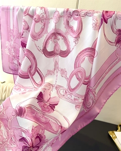 Close-up of silk scarf showing elegant chain and purple floral patterns with smooth texture