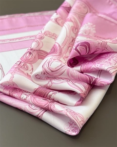 Detail of silk-feel scarf featuring premium chain print and elegant pink scrolls