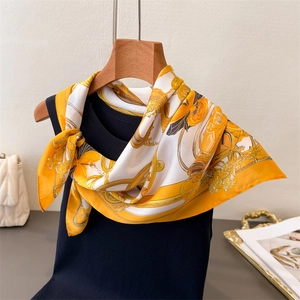 Chain print silk satin square scarf tied on a navy blue vest for elegant styling