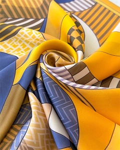 Close-up of geometric silk scarf with yellow and blue patterns and satin texture