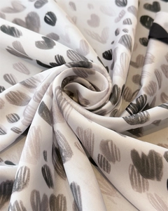 Detail eines Seidenschals mit Herz-Print und glattem Rollsaum-Finish für Damen