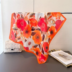 Détail d'un foulard en satin aux imprimés floraux vibrants et texture soyeuse élégante