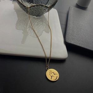 Gros plan d'un collier doré avec pendentif portrait abstrait sur vaisselle élégante