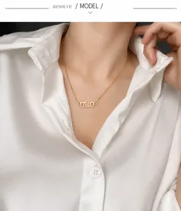 Detailed macro view of gold-finished letter pendant necklace on professional model