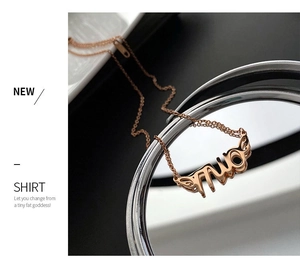 Detail of rose gold alphabet necklace with miao pendant on a reflective mirror surface