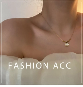 Detail of model wearing a gold smiley face shell necklace with delicate beads